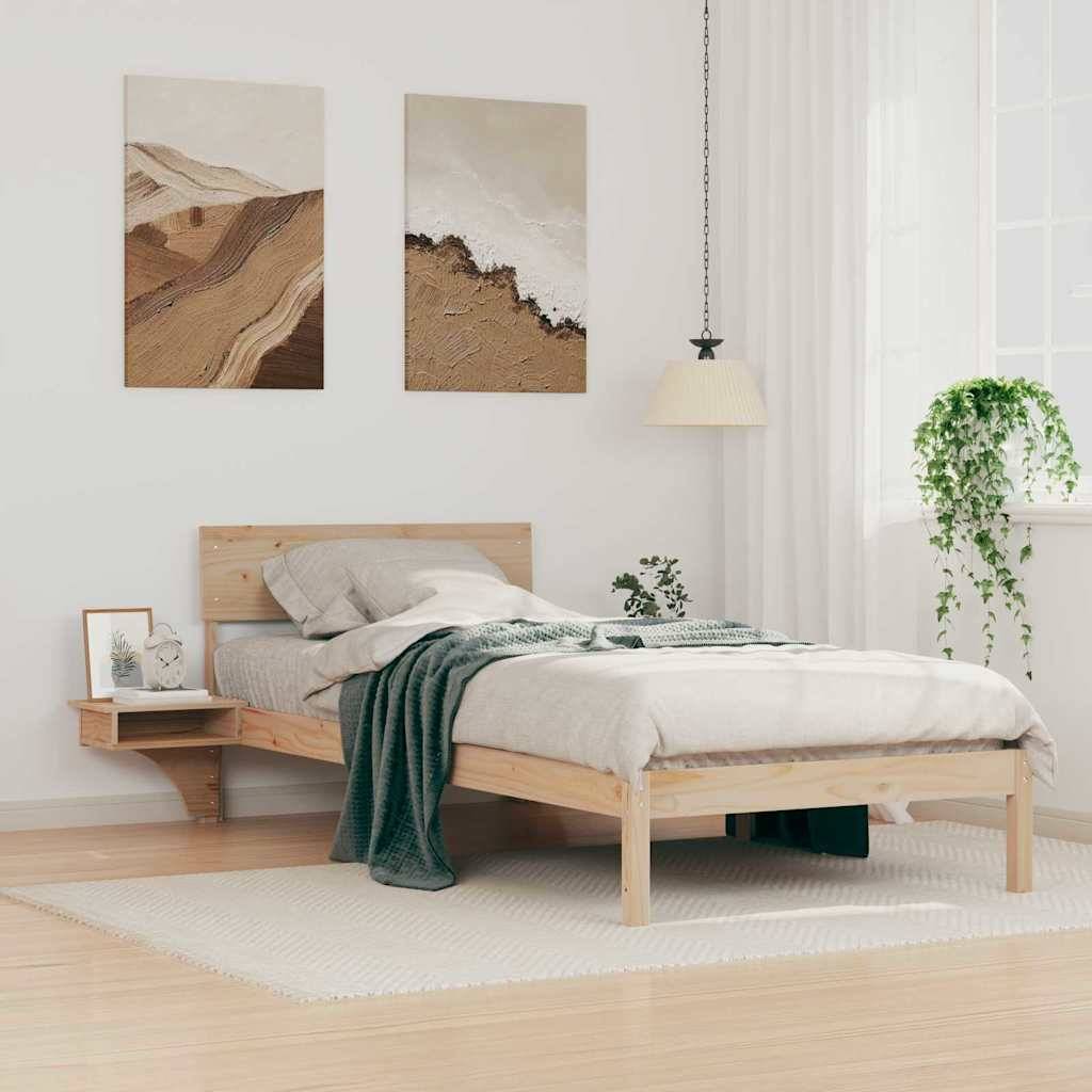 Ein minimalistisches Schlafzimmer mit einem Holzbett, einer grünen Decke und Kissen. Zwei Landschaftsgemälde hängen über dem Bett, und eine Pflanze steht in der Nähe.