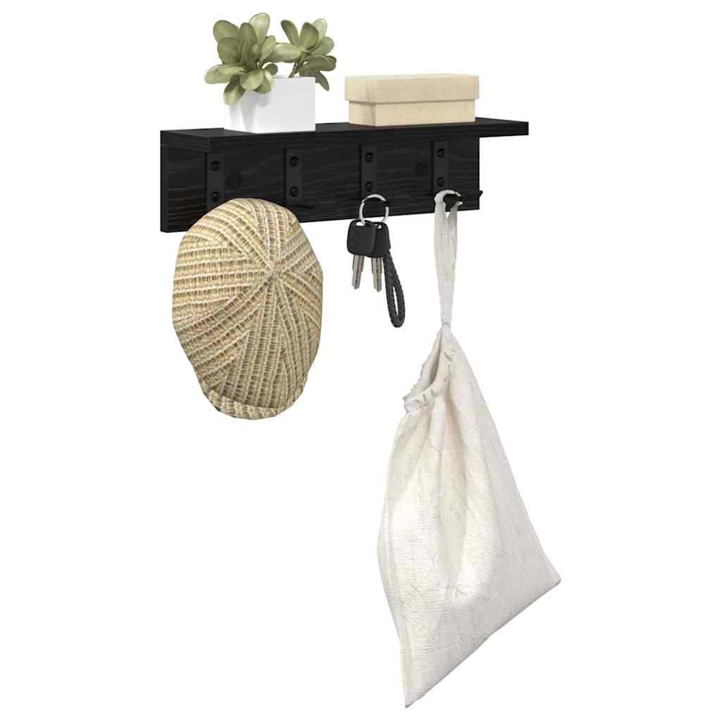 Wandmontiertes schwarzes Regal mit fünf Haken. Ein Hut, Schlüssel und eine Tasche hängen an den Haken. Das Regal trägt eine kleine Pflanze und eine Schachtel.