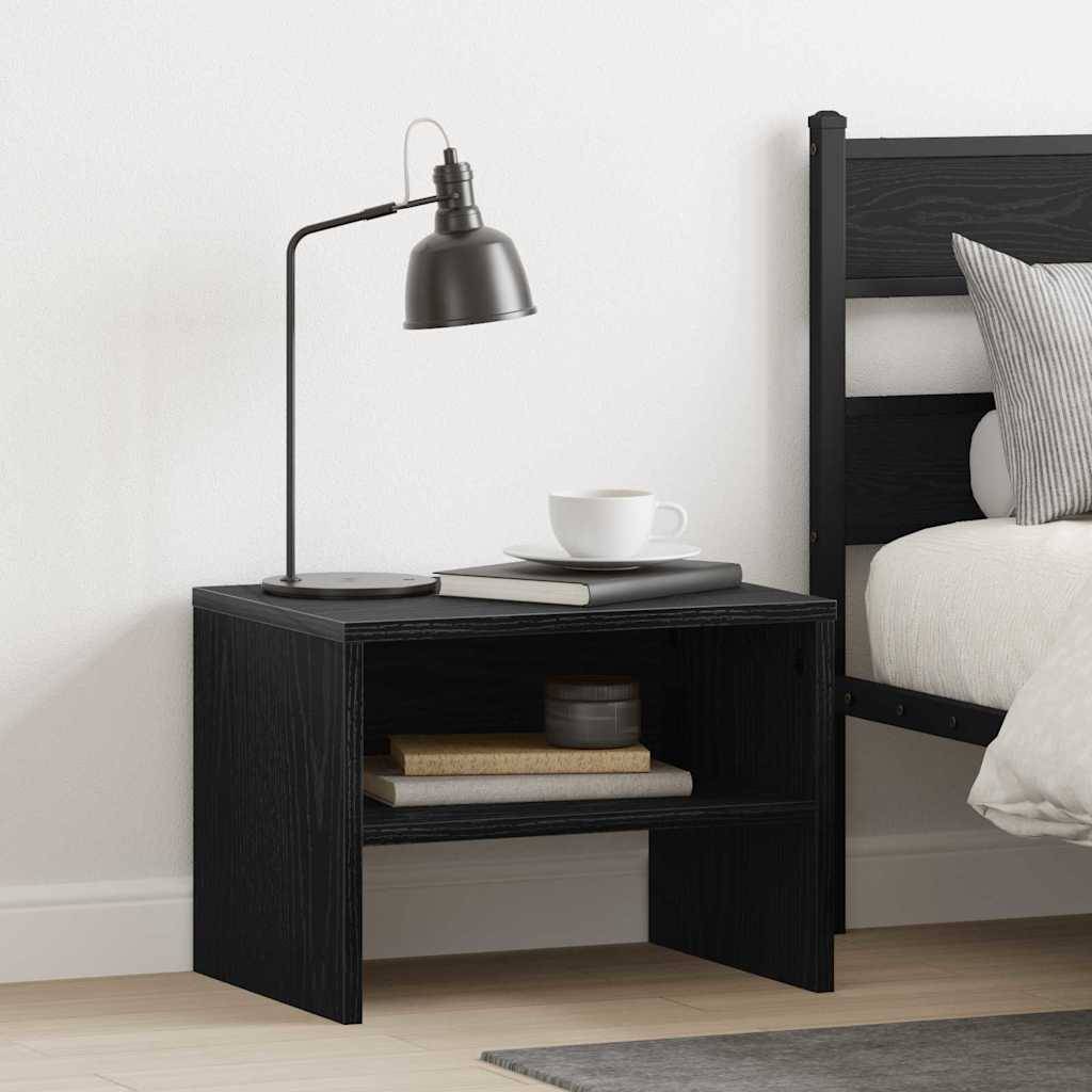 Ein Nachttisch mit einer Lampe, einer weißen Tasse und Büchern neben einem Bett mit einem weißen Kissen. Die Umgebung ist modern und minimalistisch.