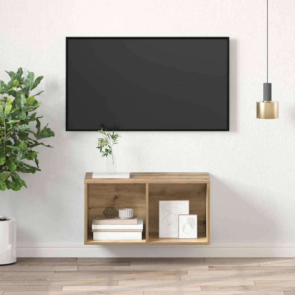 Ein modernes Wohnzimmer zeigt einen großen schwarzen Fernseher an einer weißen Wand, ein Holzregal mit Dekorationsgegenständen darunter, eine grüne Pflanze links und eine hängende Lampe.