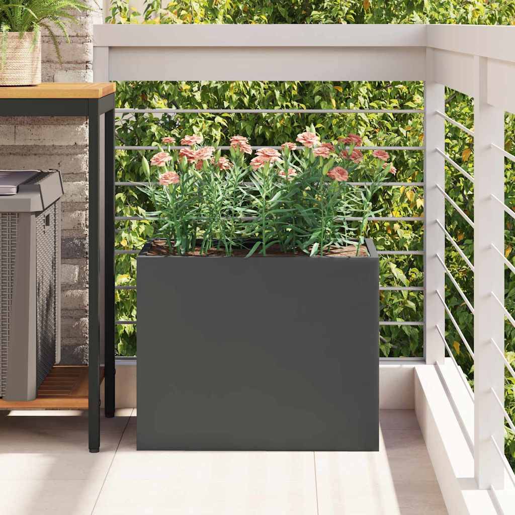 Ein Balkon mit einem großen Pflanzkasten, gefüllt mit blühenden rosa Blumen, neben einer Außenküchen-Einrichtung mit Ziegelwandhintergrund.