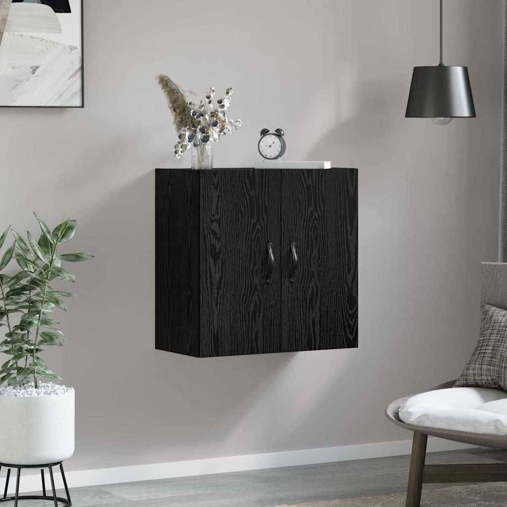 Ein modernes Wohnzimmer mit einem schwarzen Wandschrank, einer kleinen Pflanze darauf, einem runden Tisch und einem grauen Sessel. Die Dekoration umfasst eine Pflanze und ein gerahmtes Bild.