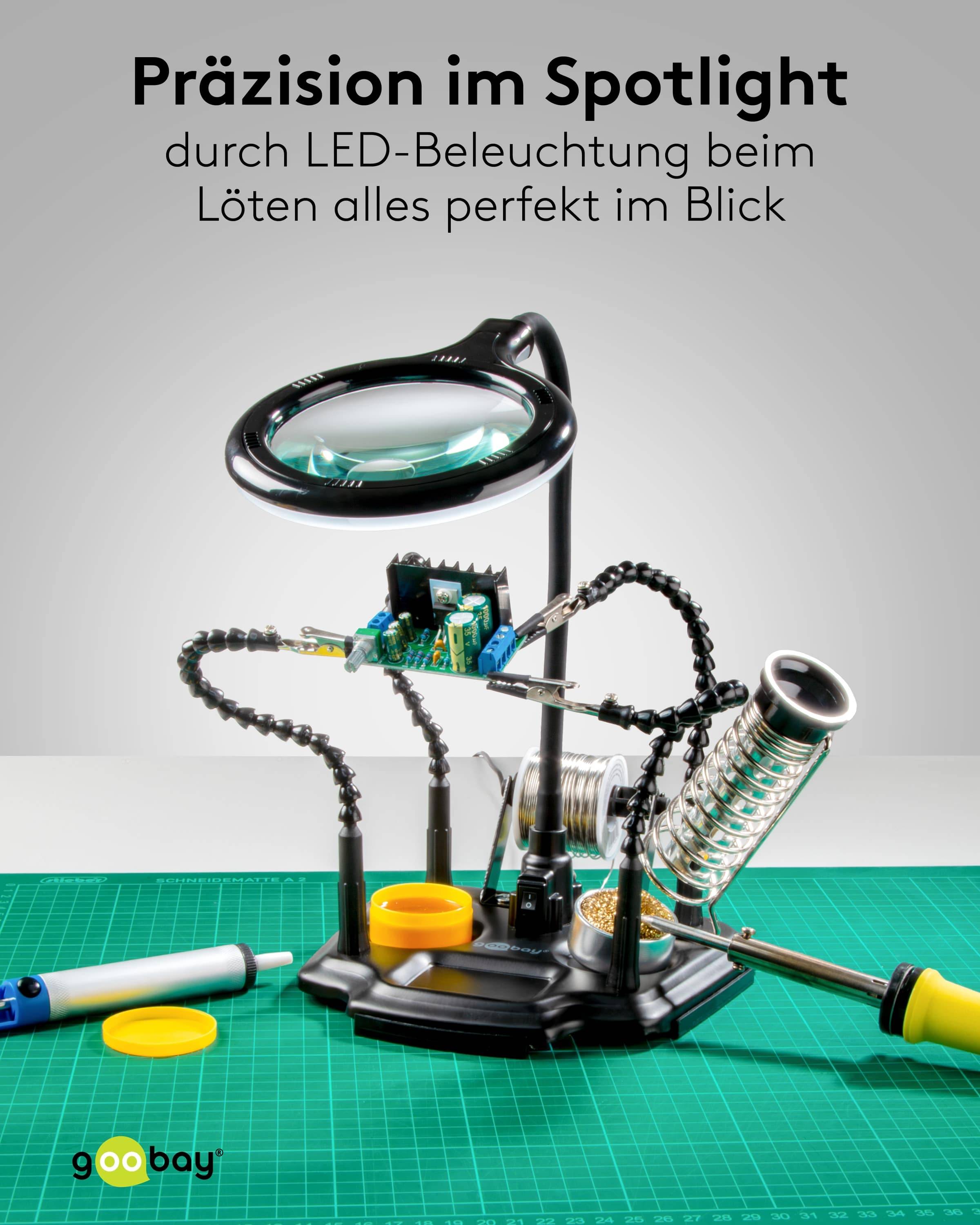 Eine Lupe mit LED-Beleuchtung ist über elektronischen Bauteilen auf einem Arbeitsplatz positioniert, begleitet von einer Lötstation.