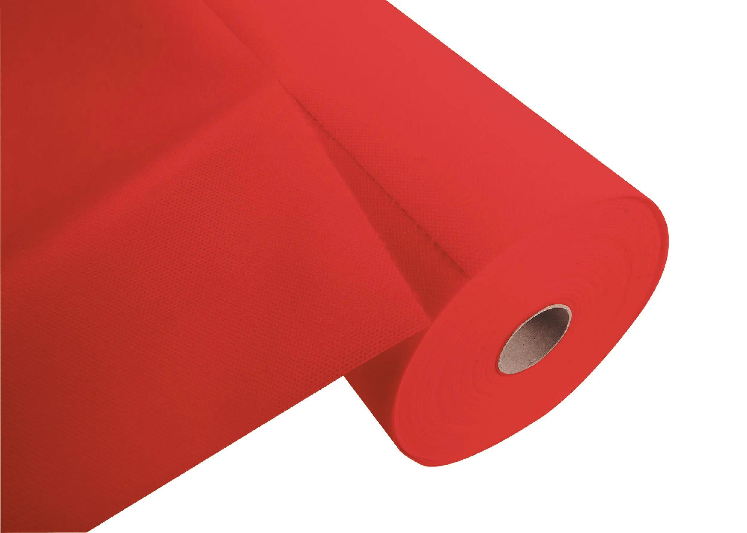 Rolle rotes Geschenkpapier, teilweise abgerollt auf weißem Hintergrund, zeigt glatte Oberfläche und leuchtende Farbe.