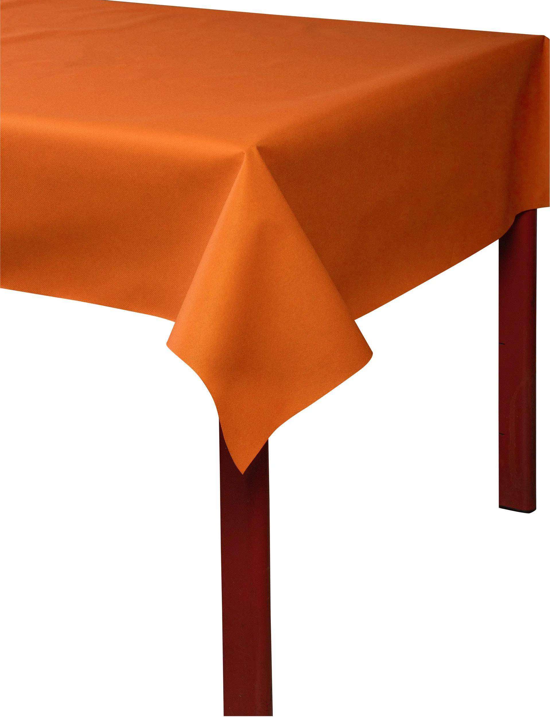 Eine orangefarbene Tischdecke, die über einen Tisch drapiert ist und ihre glatte Textur und leuchtende Farbe betont.