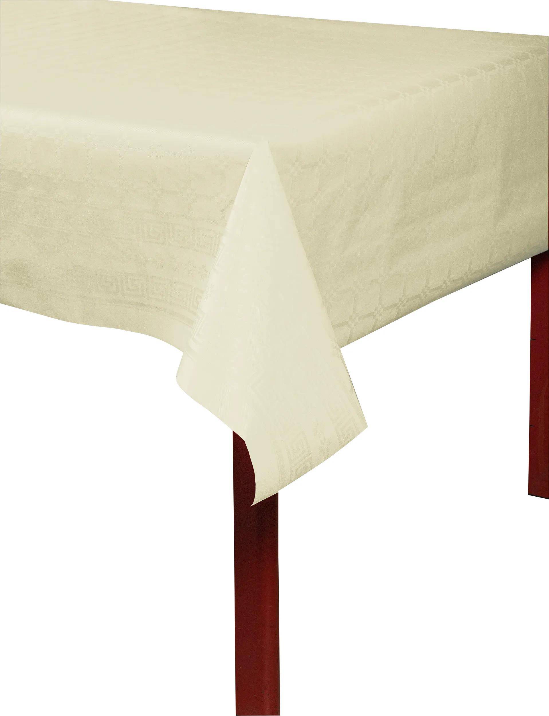 Ein cremefarbenes Tischdeckchen mit einem dezenten geometrischen Muster fällt über den Rand eines Holztisches.