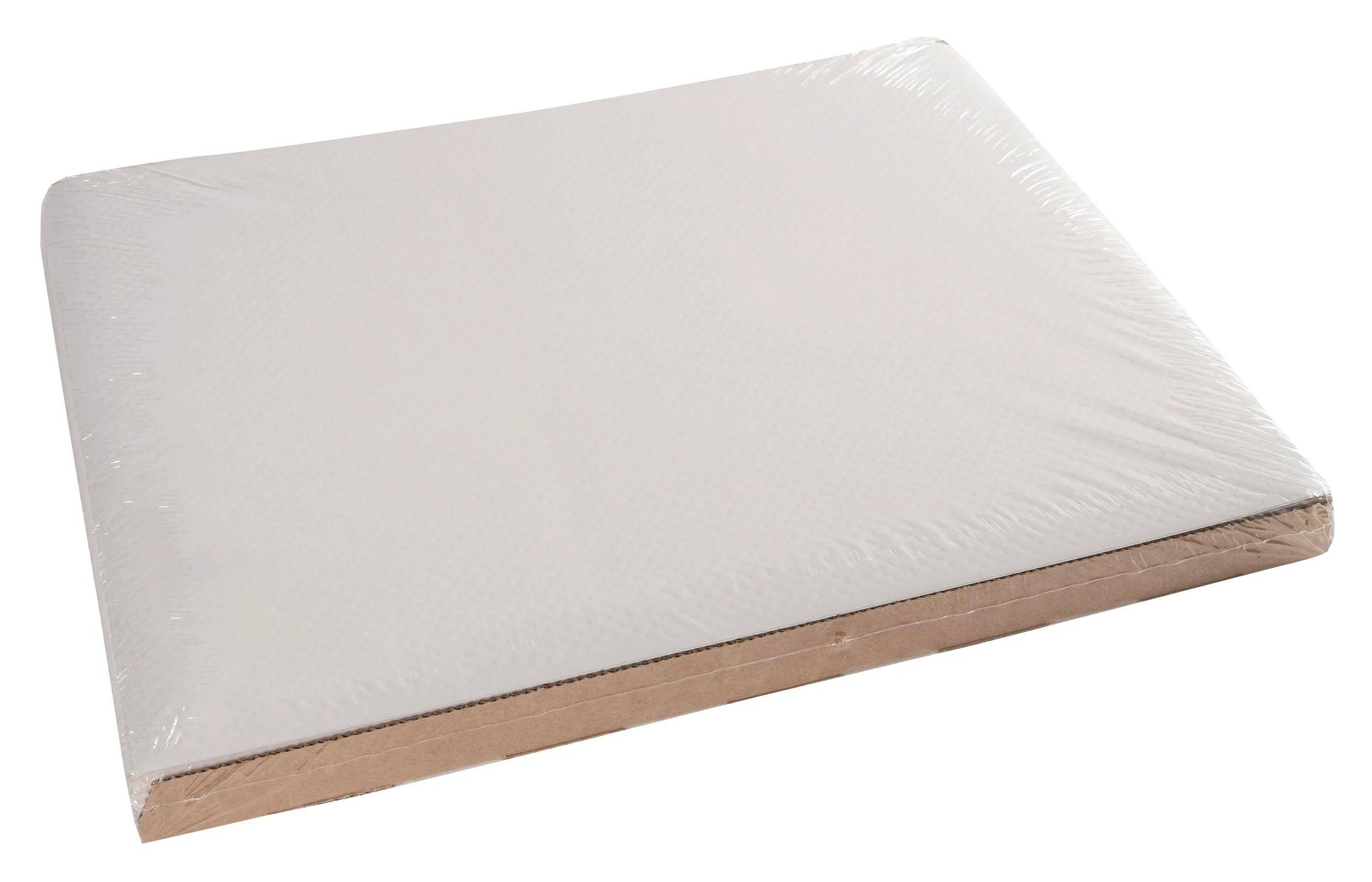 Ein einfaches, rechteckiges Blatt aus weißer gewellter Pappe mit sichtbarer Kante, fotografiert von oben, vor weißem Hintergrund.