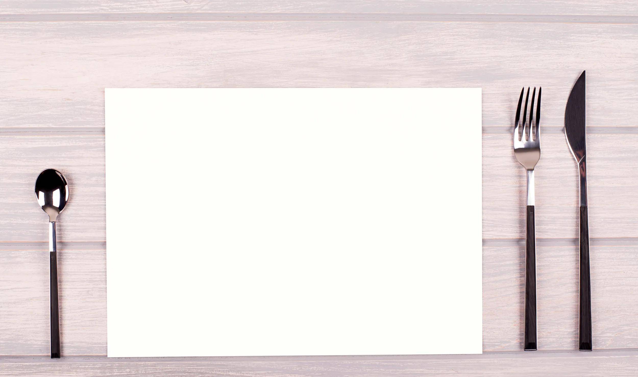 Ein weißer Umschlag auf einer hellen Holzoberfläche, leicht geöffnet, mit leerem Papier darin sichtbar.