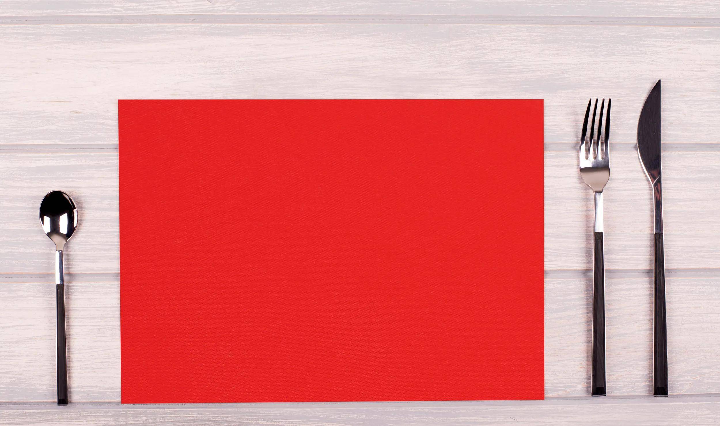 Ein leuchtend rotes Rechteck liegt zentriert auf einer hellen Holzoberfläche.