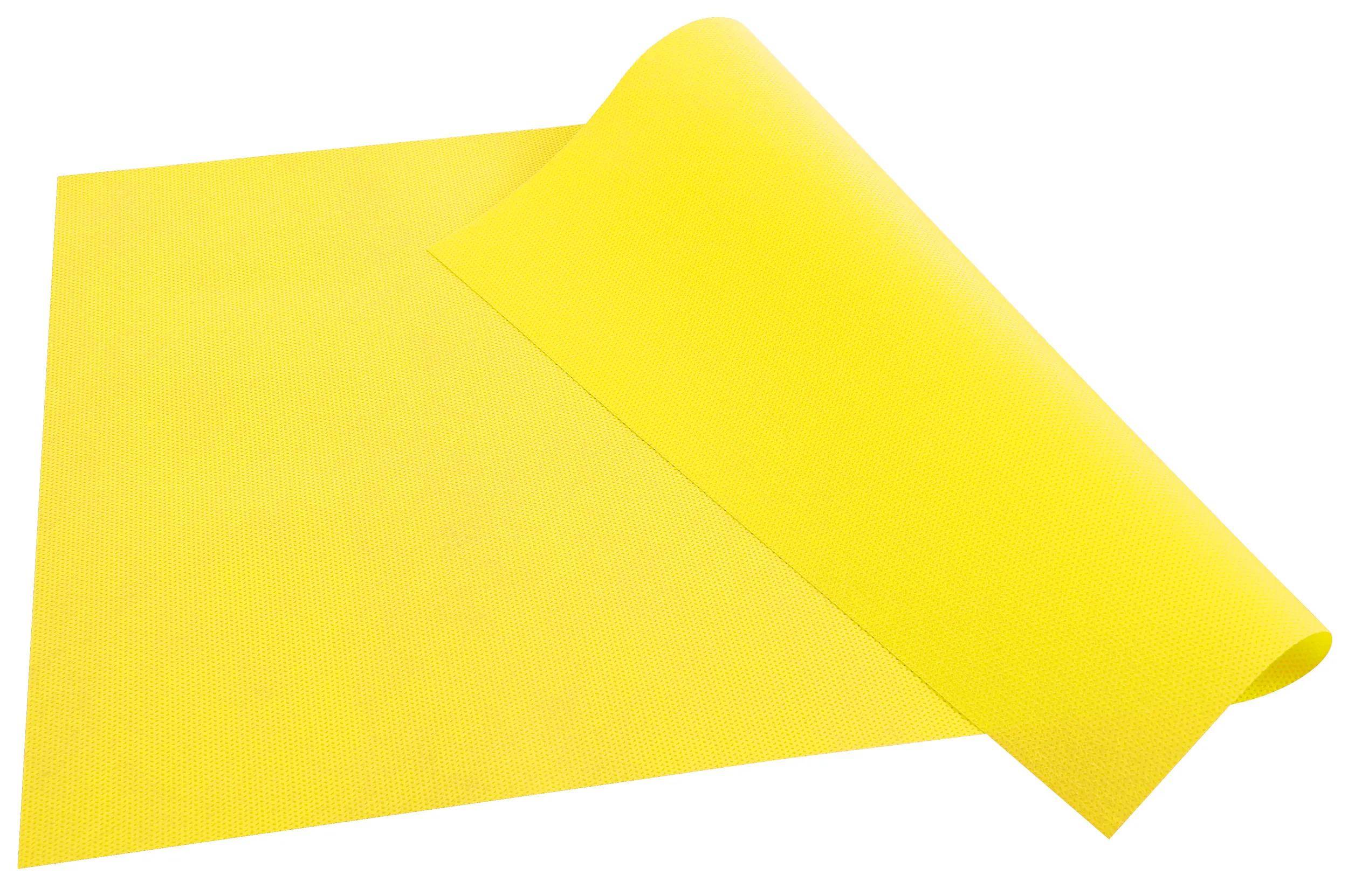 Eine leuchtend gelbe Rolle aus strukturiertem Stoff, teilweise abgerollt auf weißem Hintergrund, zeigt Farbe und Materialstruktur im Detail.