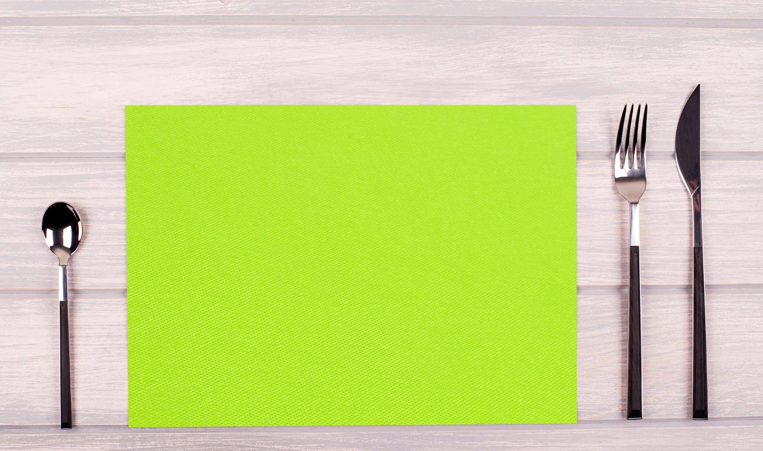 Eine lebendige hellgrüne horizontale Yogamatte auf einem helleren Holzboden.