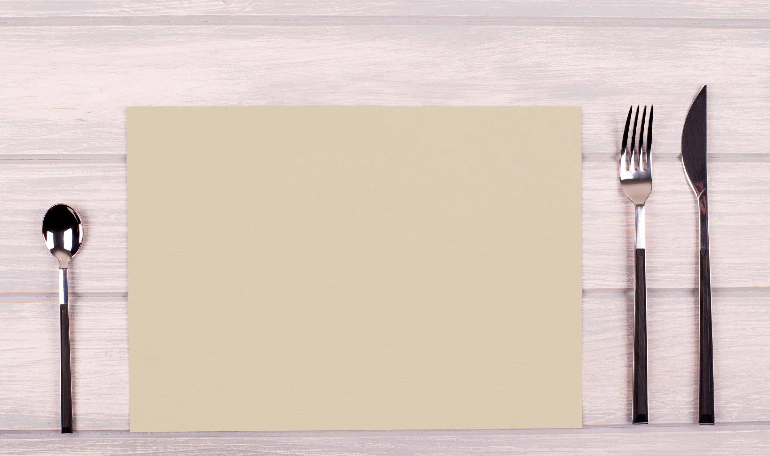 Eine leere beige rechteckige Karte auf einer hellen Holzoberfläche.