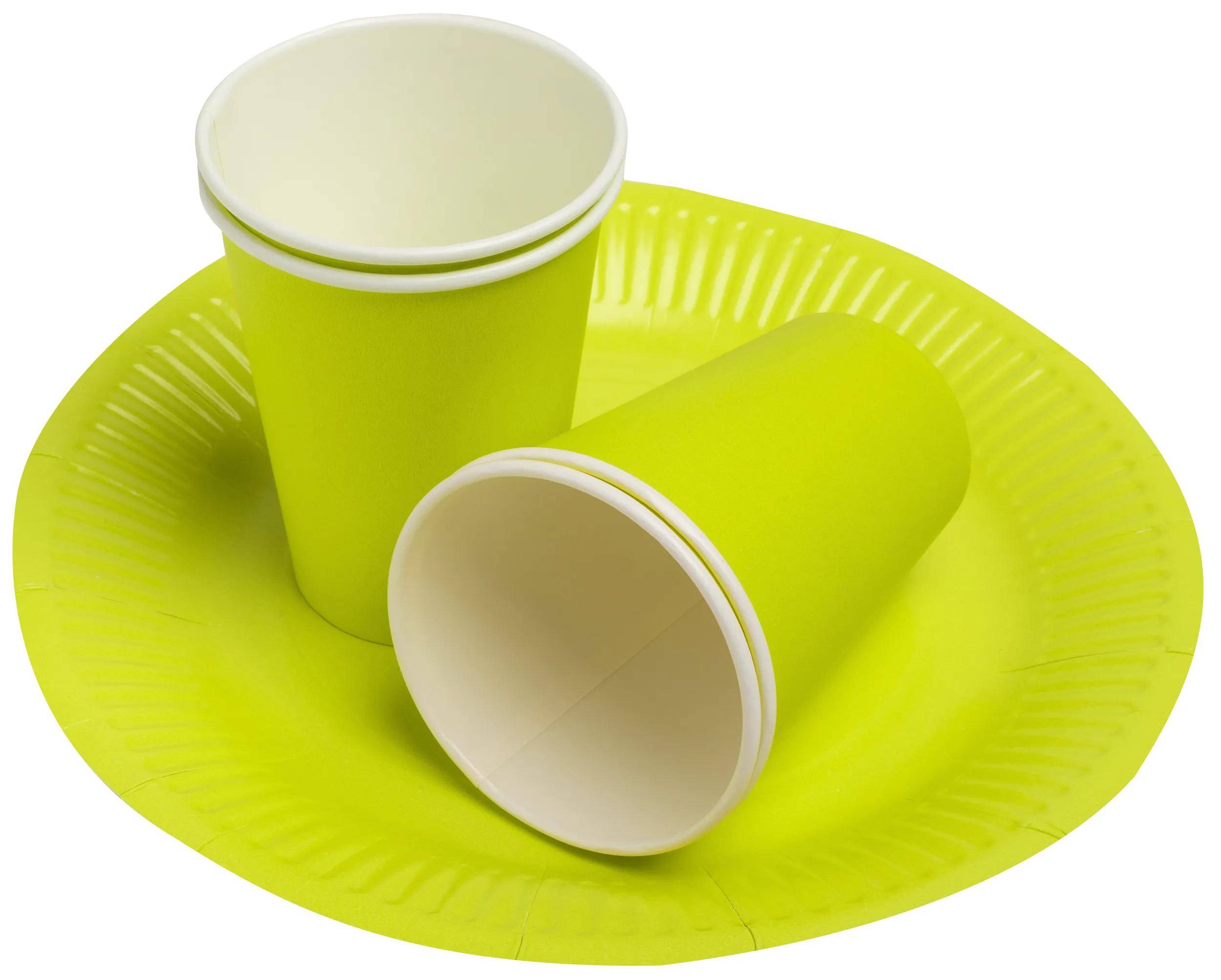 Drei grüne Papiertassen und ein passendes Teller, ordentlich angeordnet.