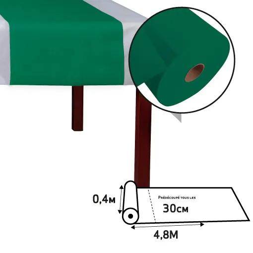 Grüne Tischdecke auf einem Tisch; Nahaufnahme zeigt eine Rolle mit einer Länge von 4,8m und einer Breite von 0,4m. Das Etikett zeigt 30cm Abstände zum Zuschneiden an.