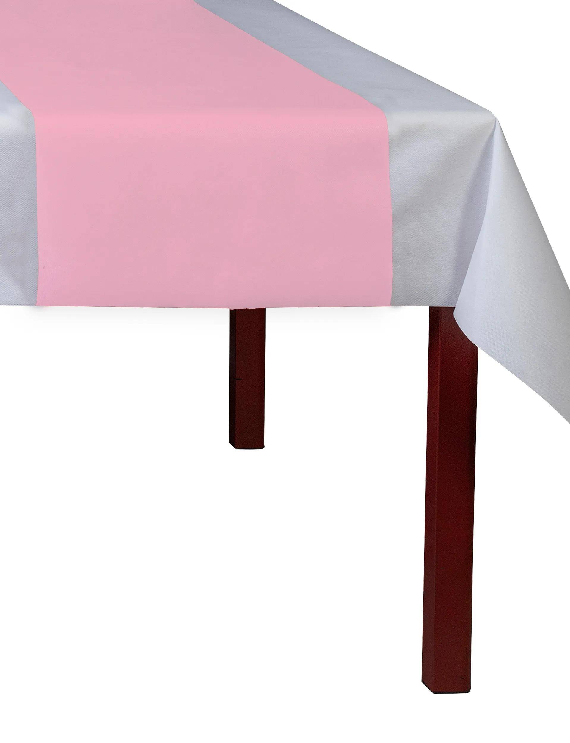 Ein Tisch ist mit einer weißen Tischdecke bedeckt und hat einen rosa Läufer in der Mitte. Der Tisch hat Holzbeine.