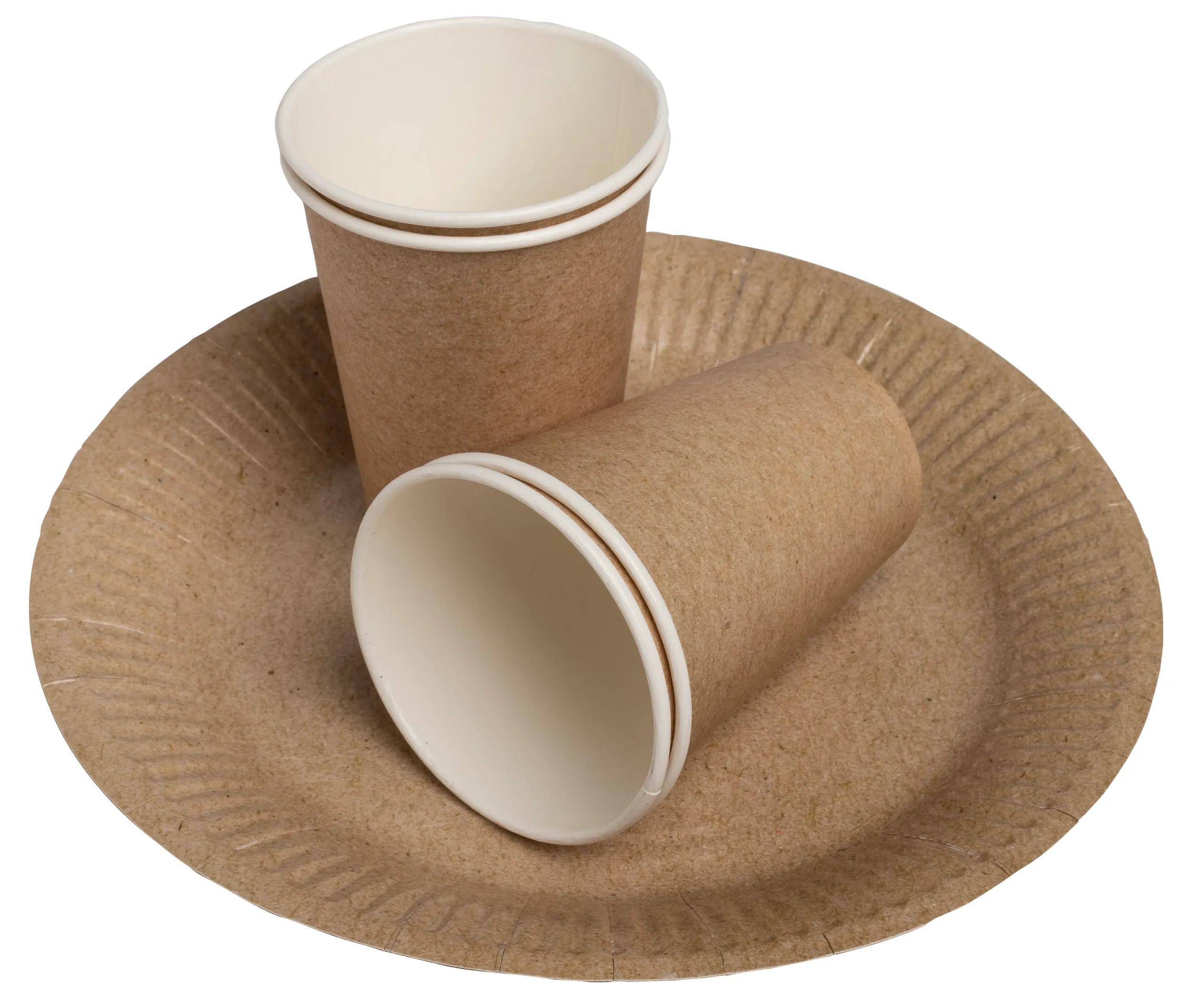Drei braune Papierbecherstehen auf einem passenden großen Papierteller angeordnet. Zwei Becher stehen aufrecht, und einer liegt auf der Seite.