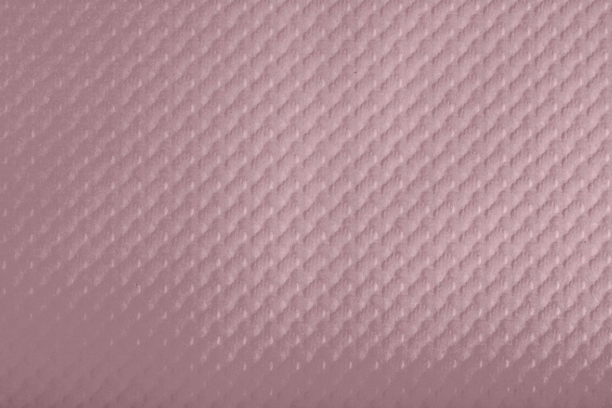 Eine Nahaufnahme einer strukturierten rosa Oberfläche mit einem Diamantmuster.
