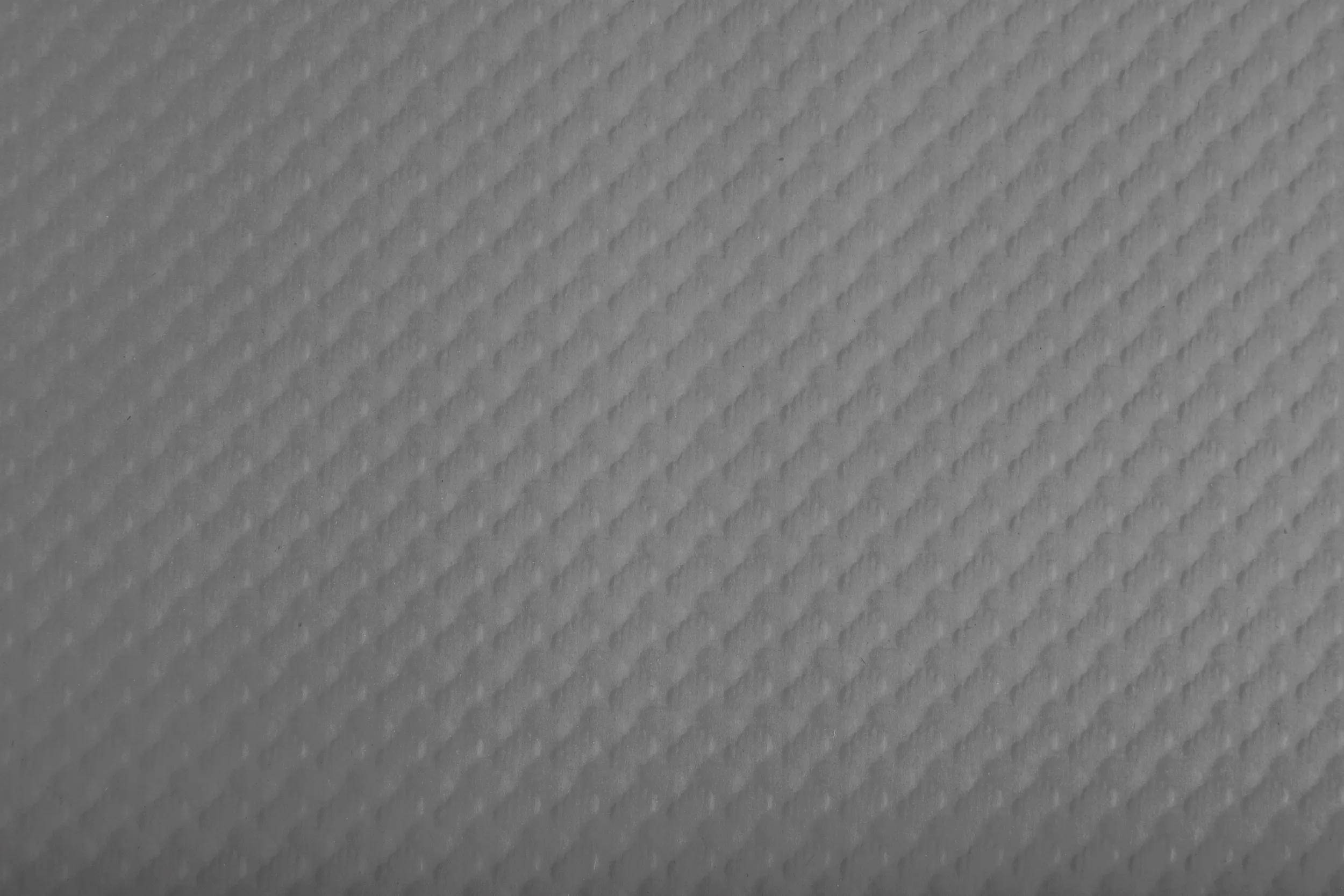 Nahaufnahme eines grauen strukturierten Musters mit einem Rautenrastermuster.