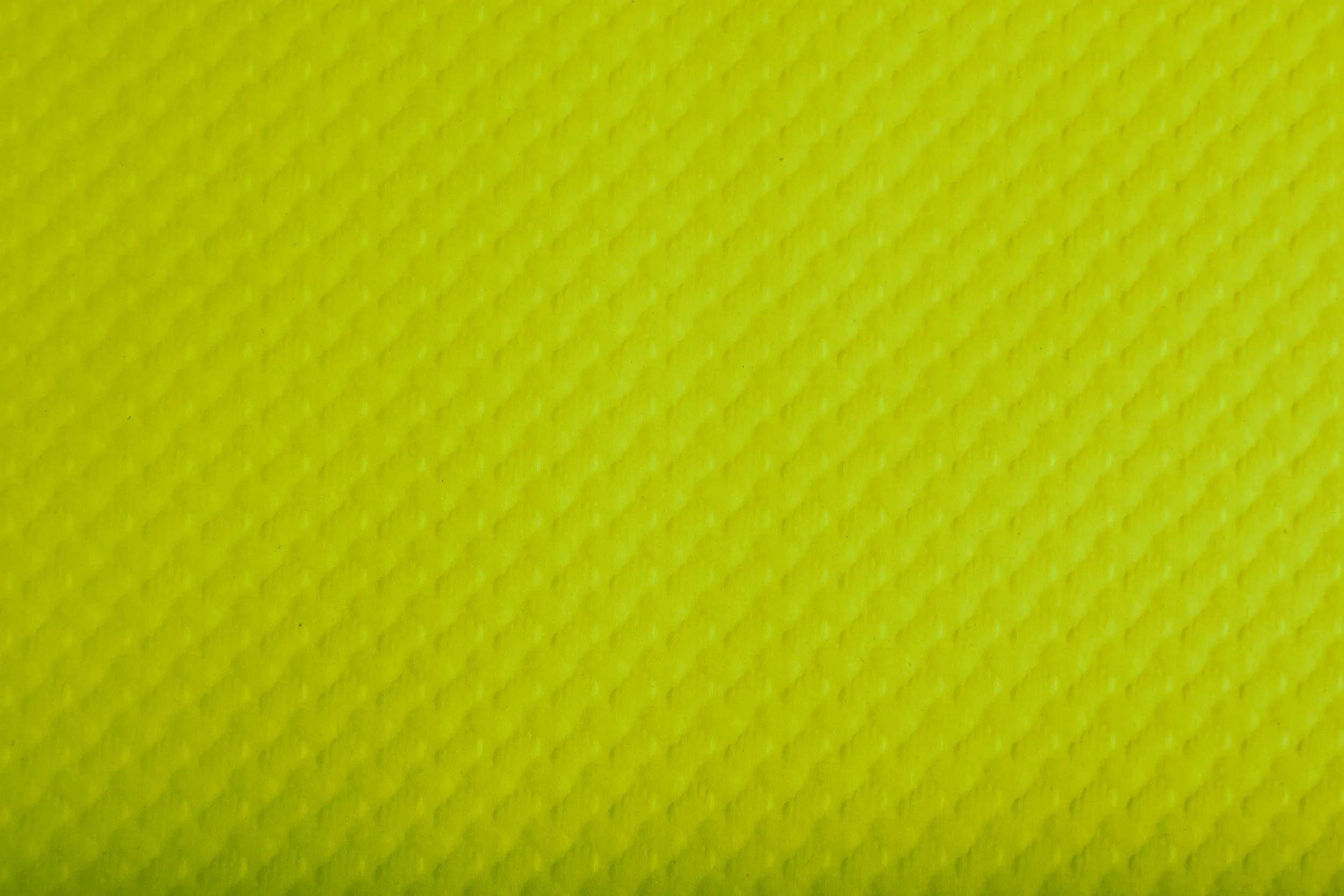 Gelber strukturierter Hintergrund mit einem subtilen Rautenmuster, das einen hellen und lebendigen visuellen Effekt erzeugt.