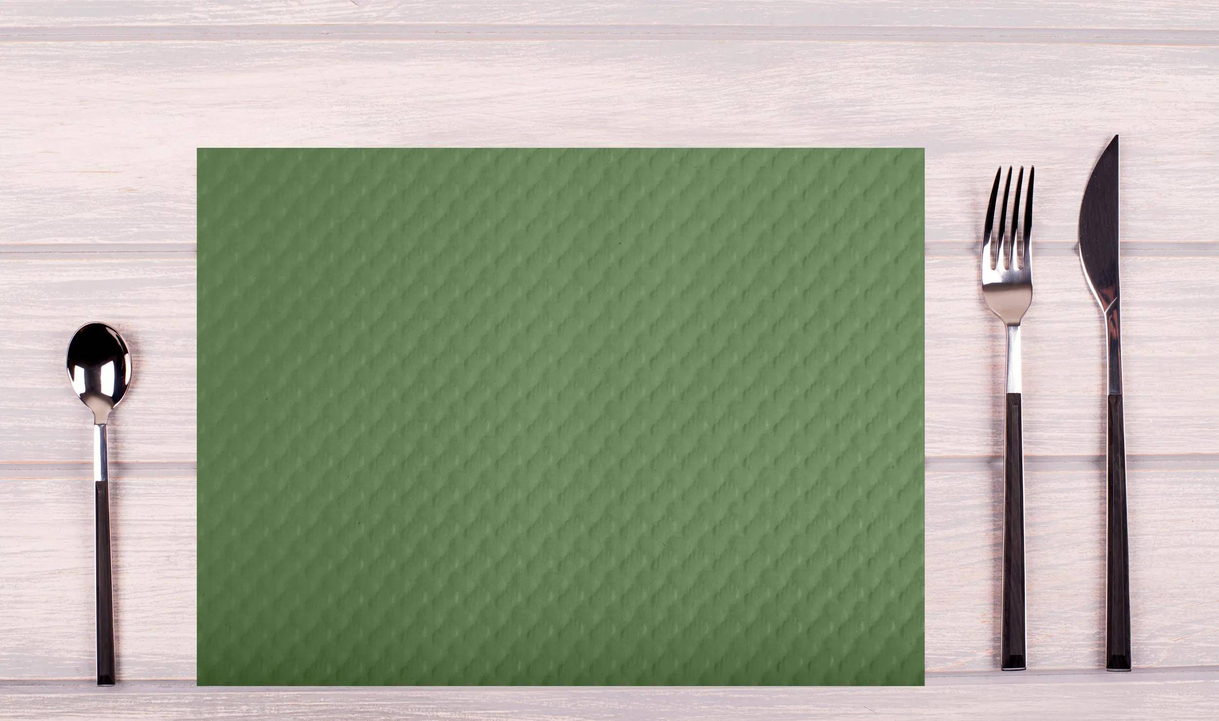 Eine grüne strukturierte Yogamatte liegt flach auf einem hellen Holzboden.