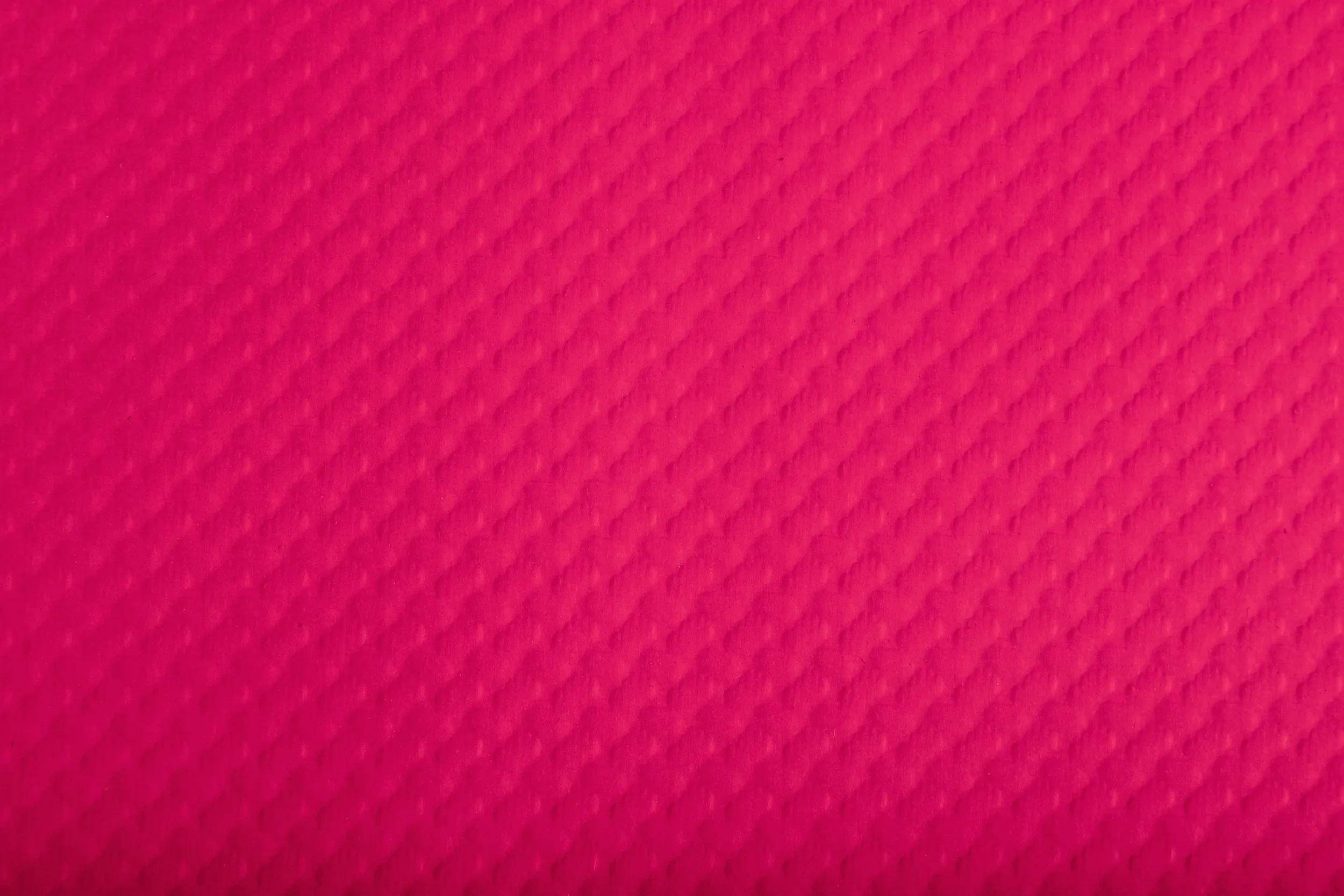 Eine Nahaufnahme einer roten strukturierten Oberfläche mit einem diagonalen Gittermuster.