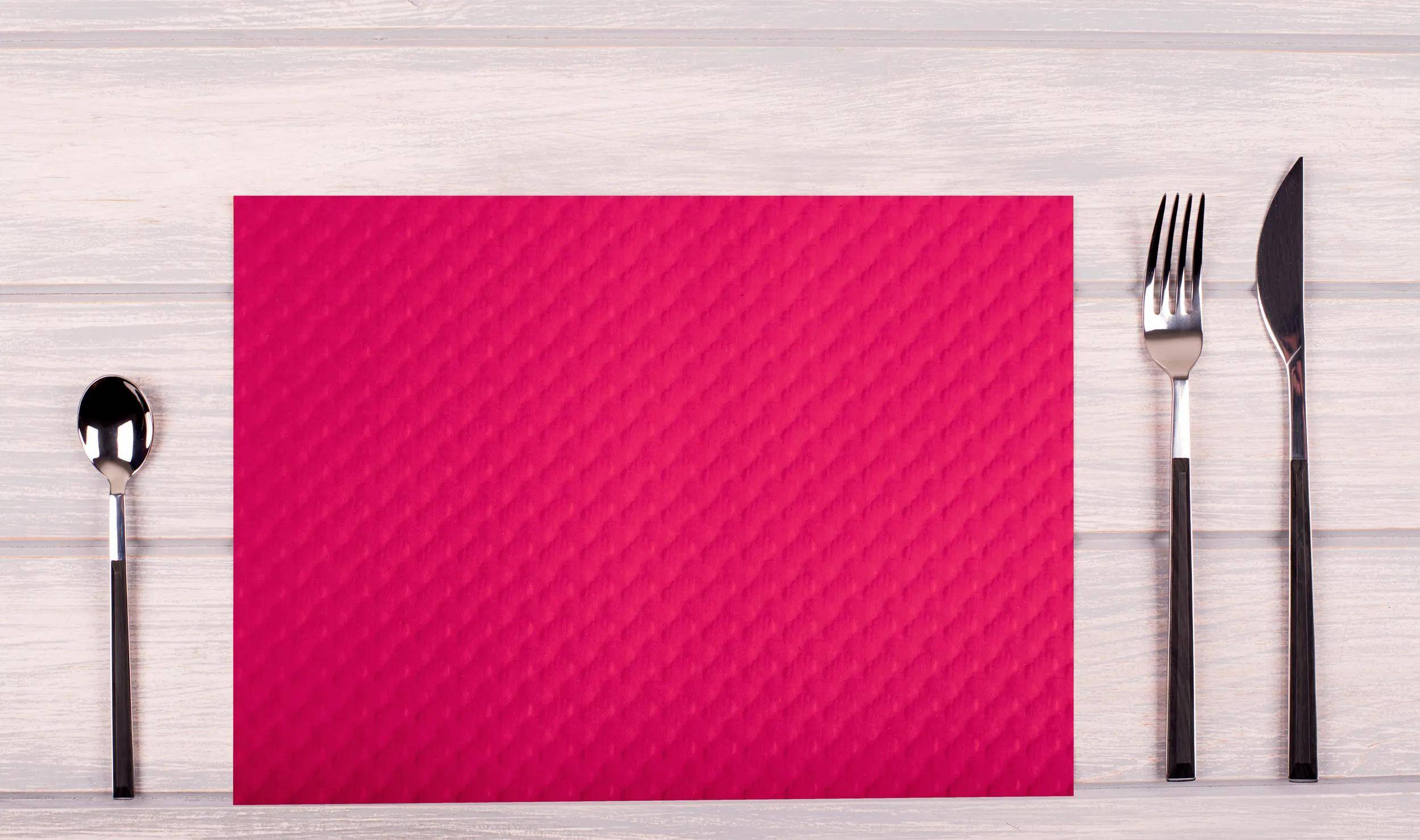 Lebendige rote strukturierte Oberfläche auf einem Holztisch, die einen auffälligen visuellen Kontrast erzeugt.