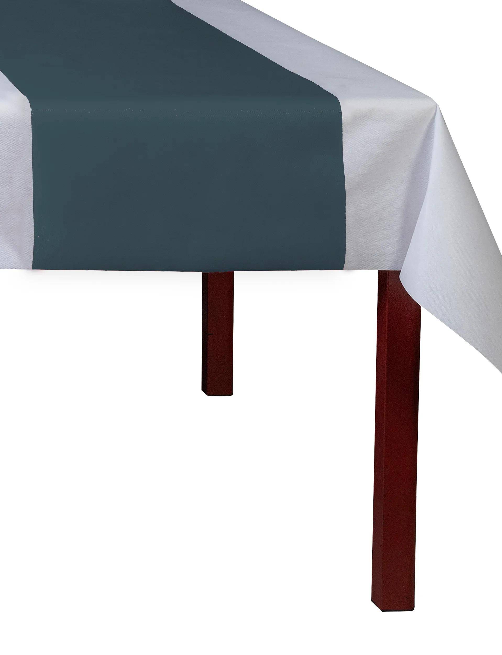 Ein weißer Tisch mit einem dunkelgrünen Läufer in der Mitte, der die roten Beine teilweise verdeckt.