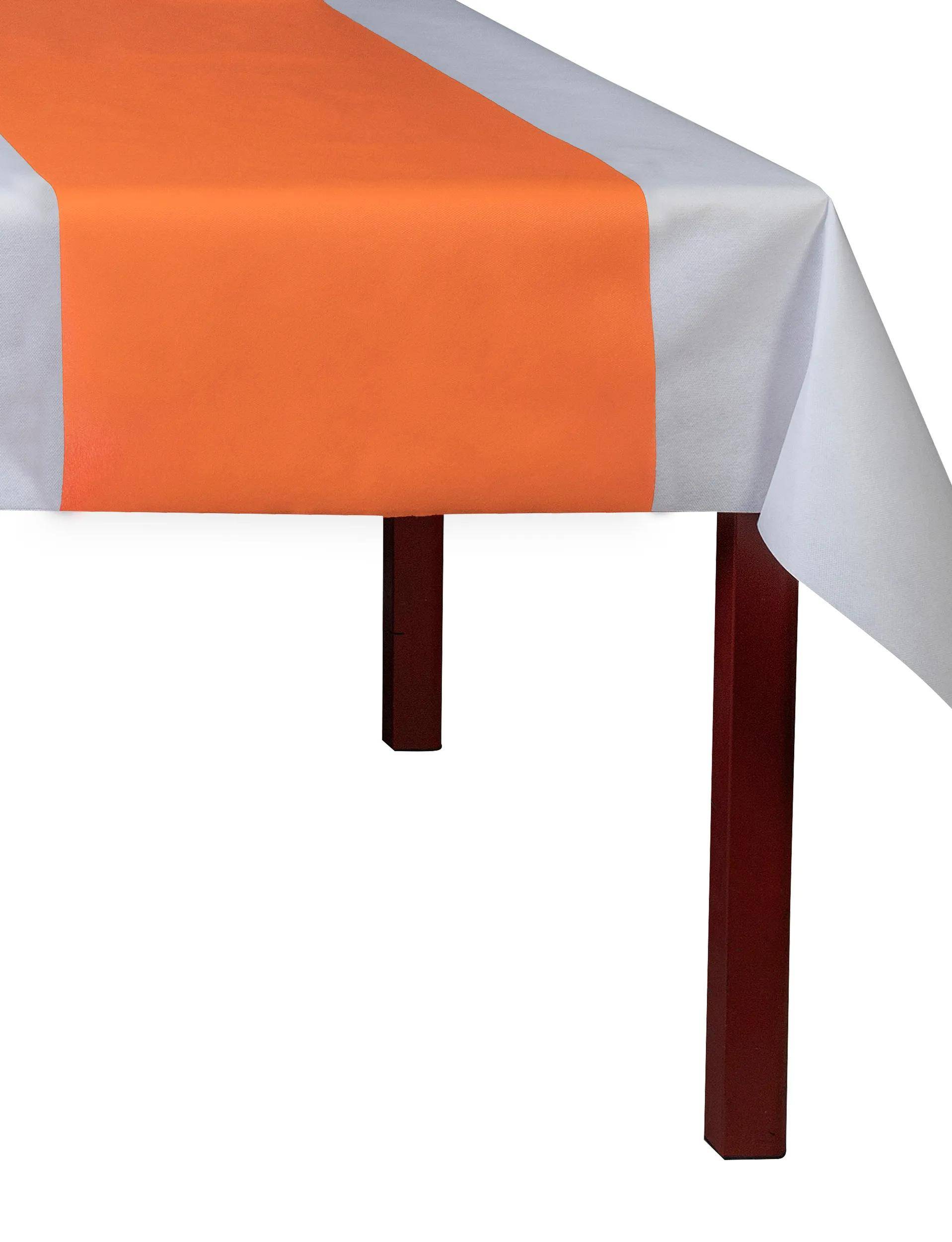 Ein Tisch mit einem weißen Tuch und einem orangefarbenen Läufer in der Mitte, aus einem Eckwinkel betrachtet. Der Tisch hat Holzbeine.
