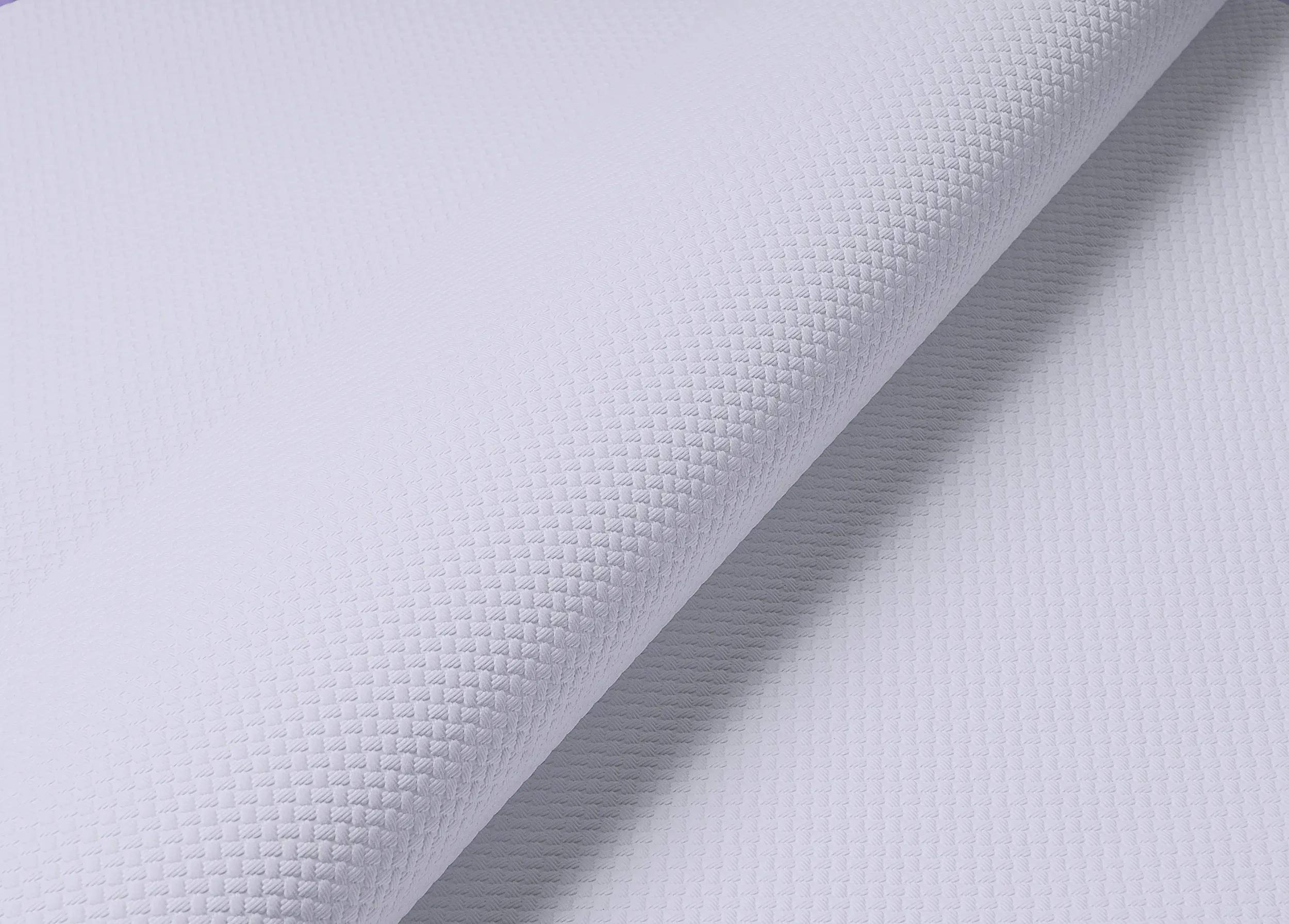 Nahaufnahme eines weißen strukturierten Gewebes mit einem subtilen Rautenmuster, das seine detaillierte Webstruktur und weiche Oberfläche zeigt.