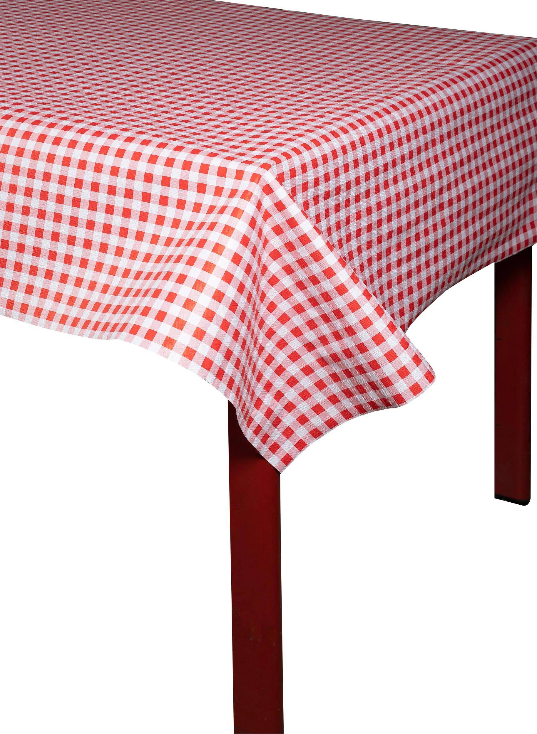 Ein Tisch mit einer rot-weiß karierten Tischdecke, wobei eine Ecke des Tisches mit roten Holzbeinen zu sehen ist.