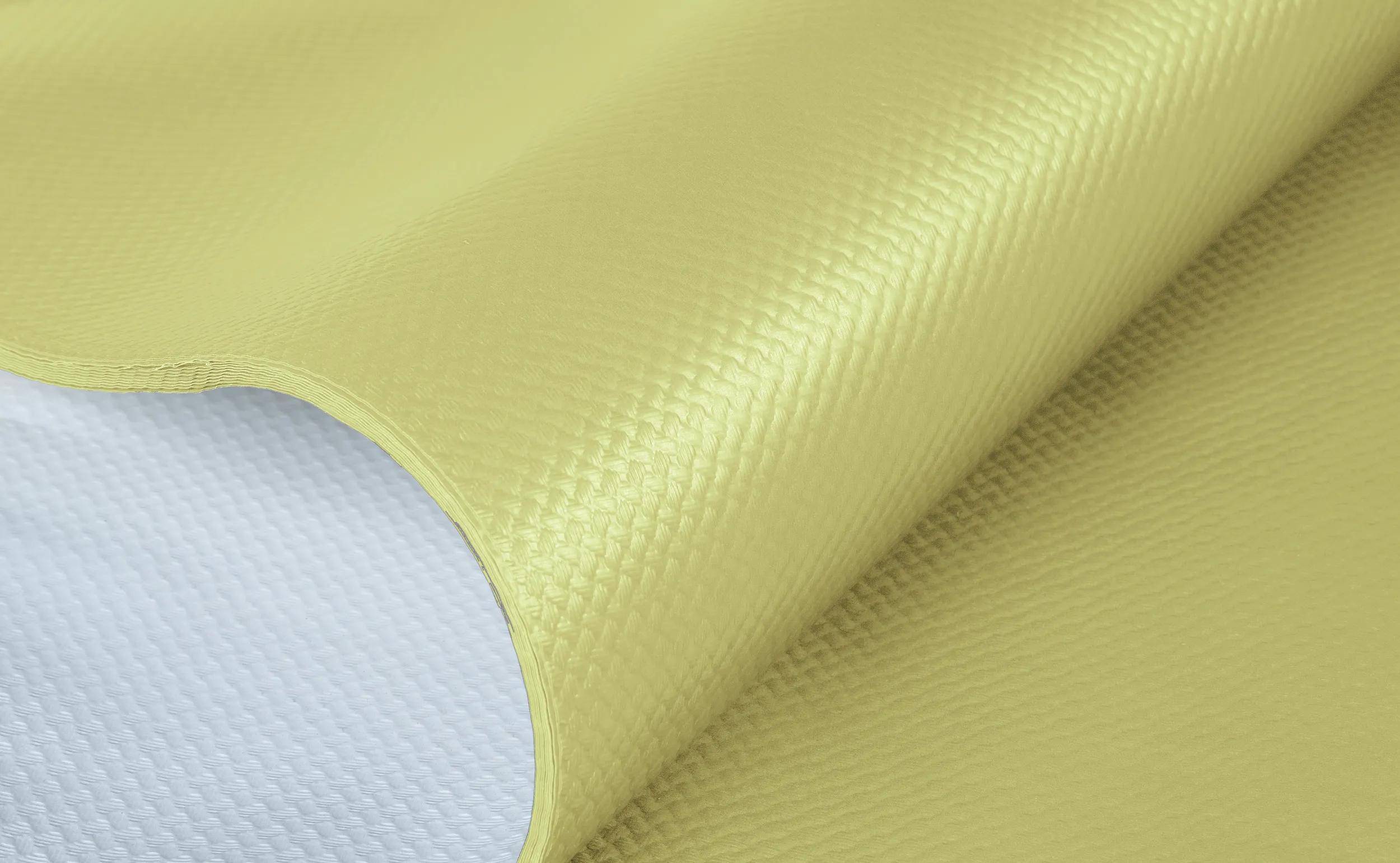 Eine Großaufnahme einer Rolle aus laminiertem Stoff mit einer strukturierten gelben Oberfläche und glatter weißer Unterseite, die die Oberflächenbeschaffenheit des Materials zeigt.