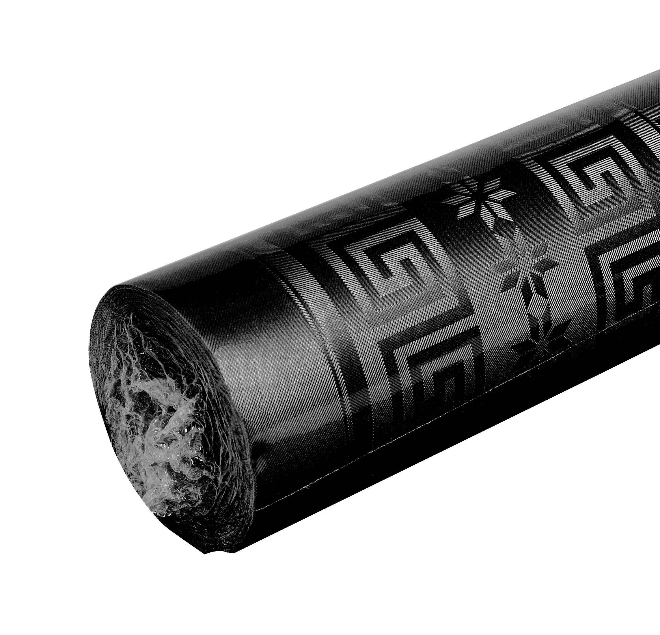 Eine Rolle schwarzer Stoff mit geometrischen Mustern, die Quadrate und Sterne zeigen, teilweise ausgerollt, mit einer strukturierten Oberfläche.