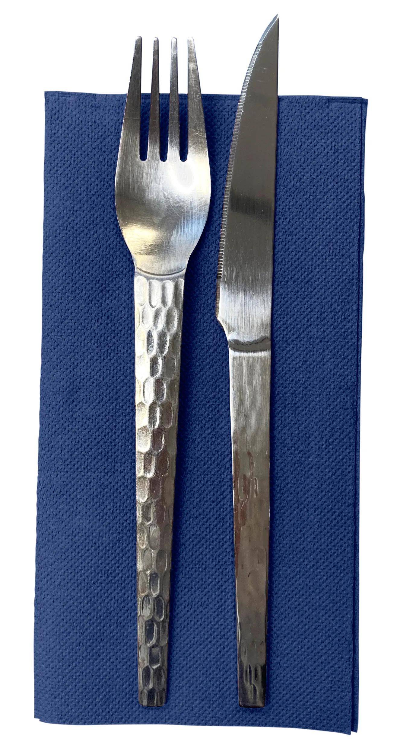 Ein silberner Löffel und ein Messer auf einer gefalteten blauen Serviette.