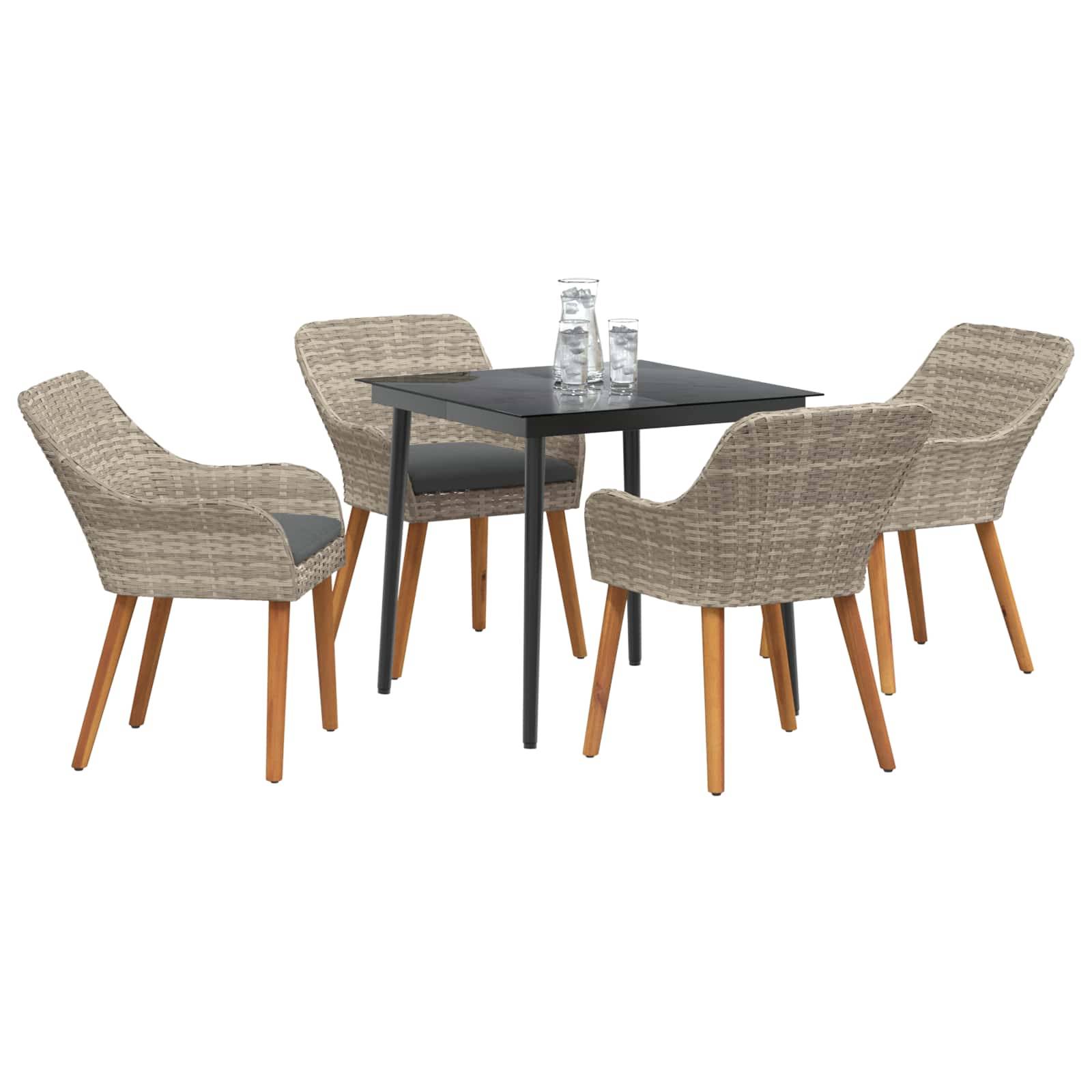 Outdoor-Essgruppe mit einem quadratischen schwarzen Tisch und vier Sesseln aus Geflecht mit Holzbeinen. Zwei Gläser stehen auf dem Tisch.