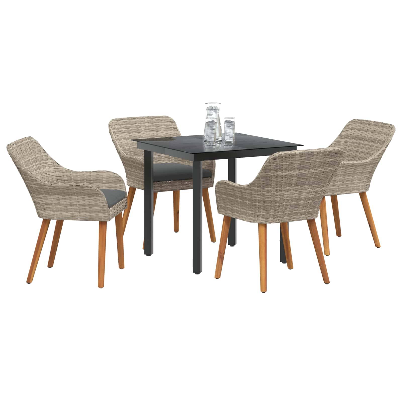 Outdoor-Essgruppe mit einem quadratischen schwarzen Tisch und vier Rattanstühlen mit Holzbeinen, wobei jeder Stuhl ein Sitzkissen aufweist. Zwei Gläser stehen auf dem Tisch.
