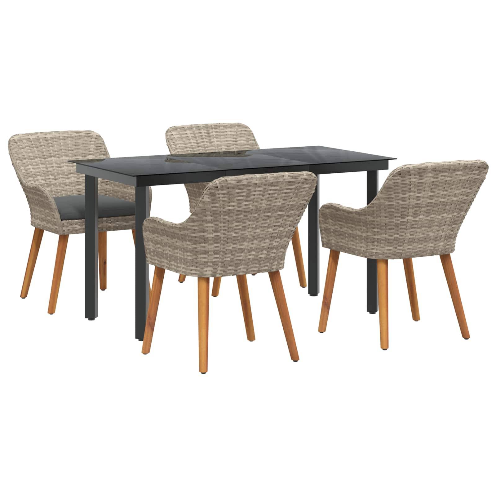 Ein Essensemble mit einem schwarzen rechteckigen Tisch und vier Rattanstühlen mit Holzbeinen, arrangiert in einem hellen Raum.
