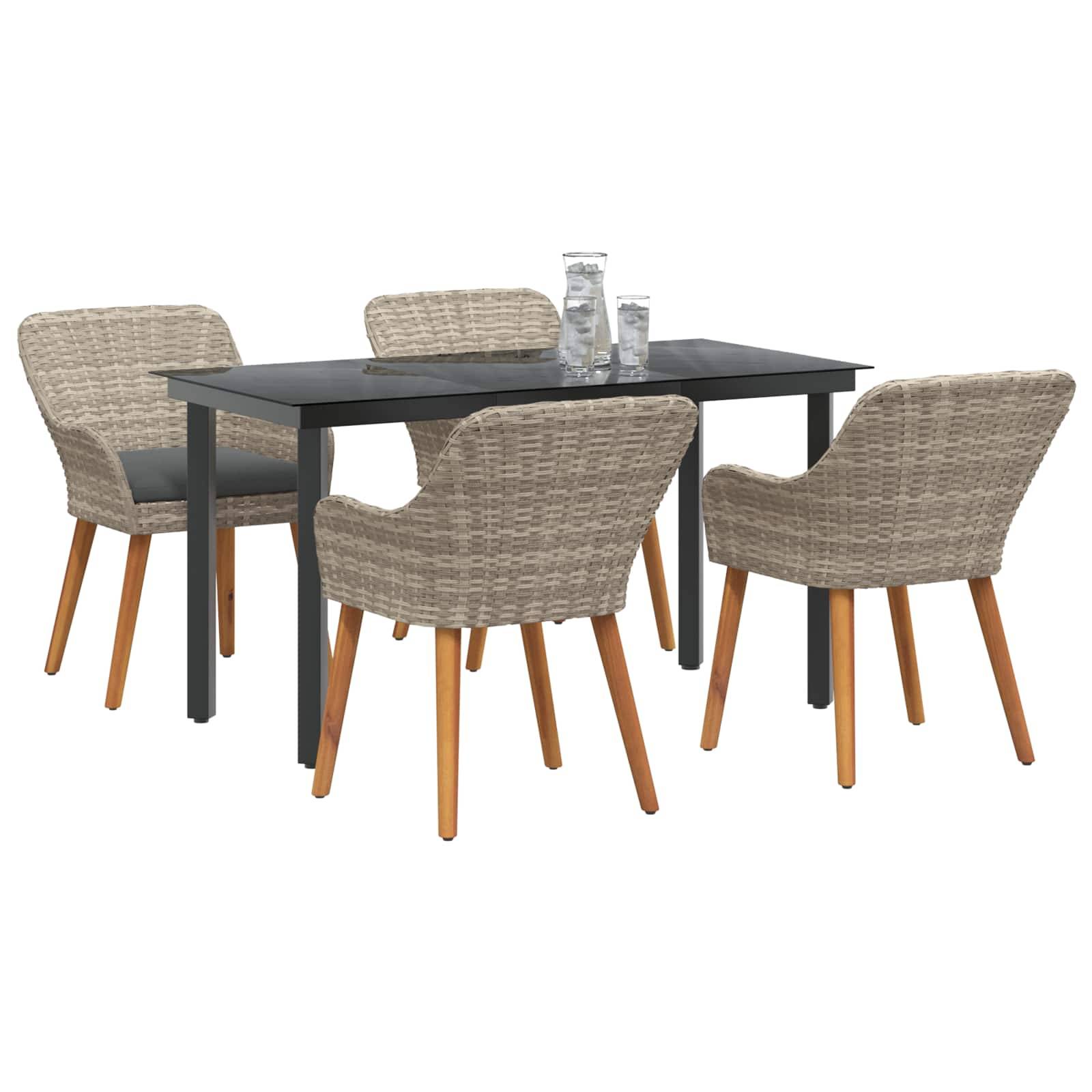 Outdoor-Essgruppe mit einem rechteckigen Tisch und vier Rattanstühlen. Der Tisch ist schwarz mit Holzbeinen. Gläser und eine Kanne stehen auf der Tischplatte.