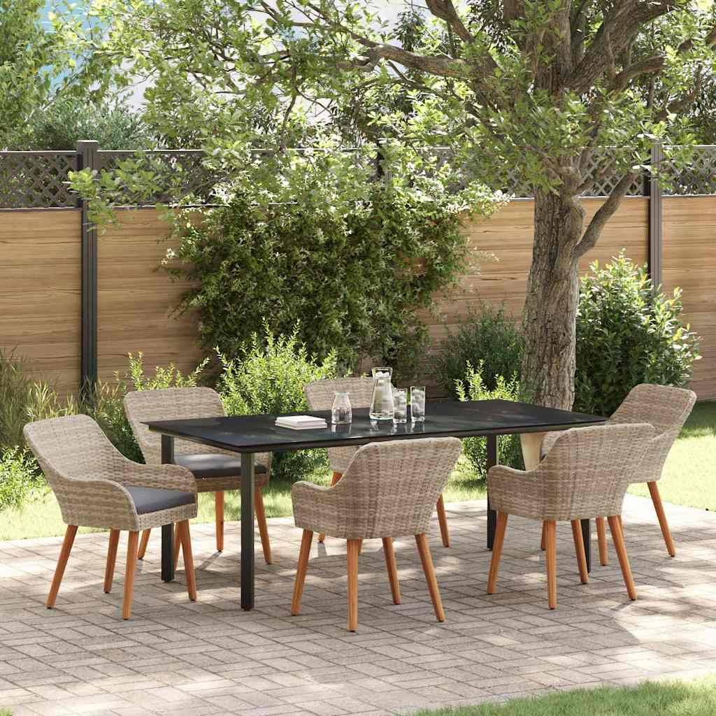 Outdoor-Essgarnitur unter einem Baum mit sechs Korbstühlen um einen rechteckigen Tisch auf einer Terrasse, umgeben von Grünpflanzen.