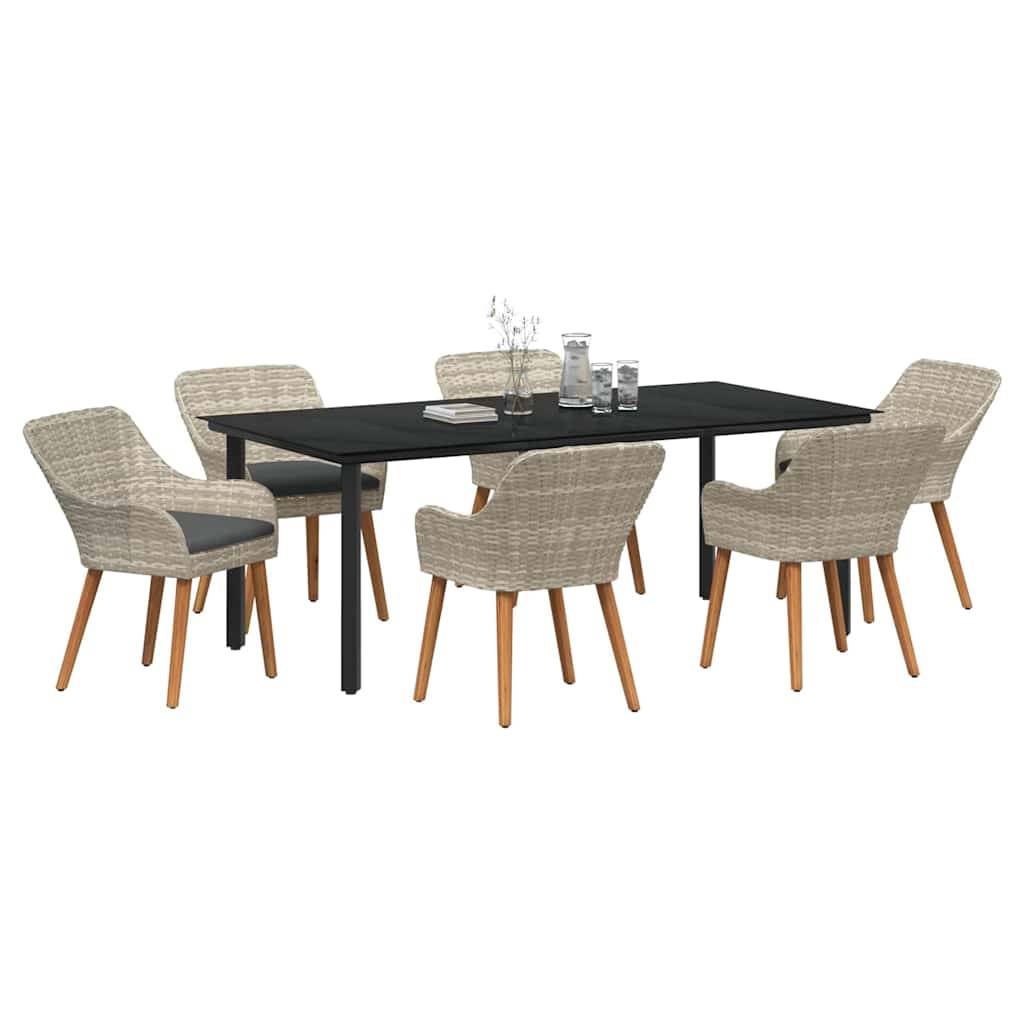 Ein rechteckiger schwarzer Tisch mit sechs Korbstühlen, die Holzbeine haben, steht im Freien mit einigen Büchern und Glasflaschen auf dem Tisch.