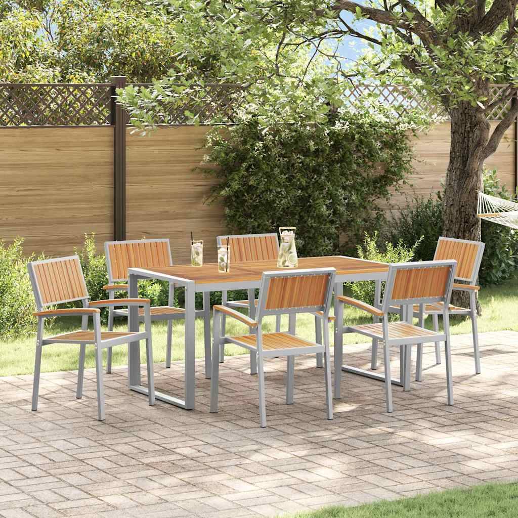 Eine Terrassenszene mit einem Holz-Esstisch-Set, umgeben von sechs passenden Stühlen auf einer gepflasterten Fläche, vor einem Holzzaun und üppigen grünen Sträuchern.