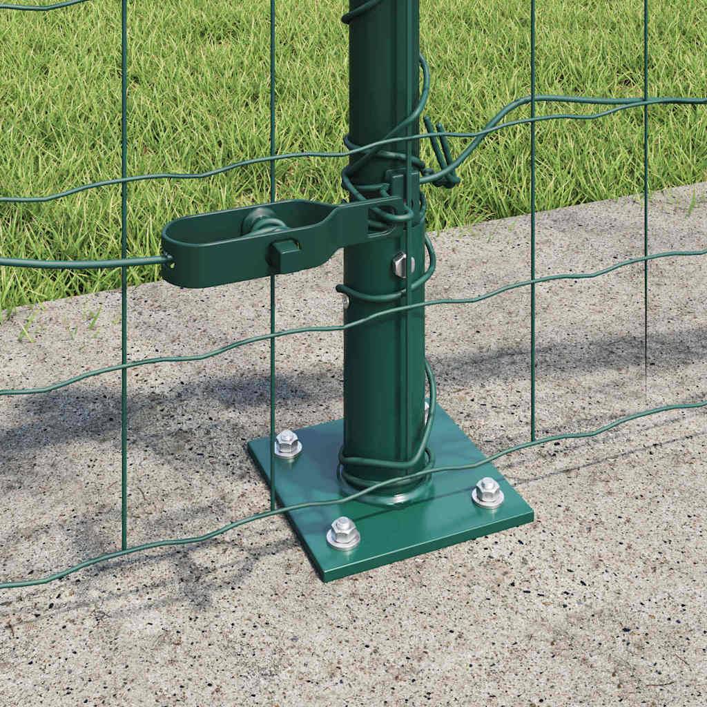 Ein grüner Metallzaunpfosten ist auf einem Betonsockel montiert und mit Bolzen befestigt. Maschendrahtzaun ist angebracht und umschließt eine mit Gras bewachsene Fläche.