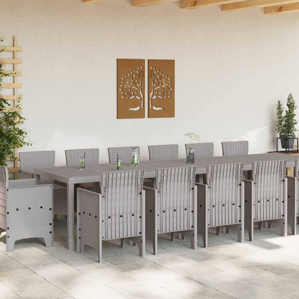 Ein langer Esstisch für zwölf Personen auf einer Terrasse, geschmückt mit kleinen Pflanzen. Zwei kunstvolle Gemälde mit Baummotiven hängen an einer Wand.