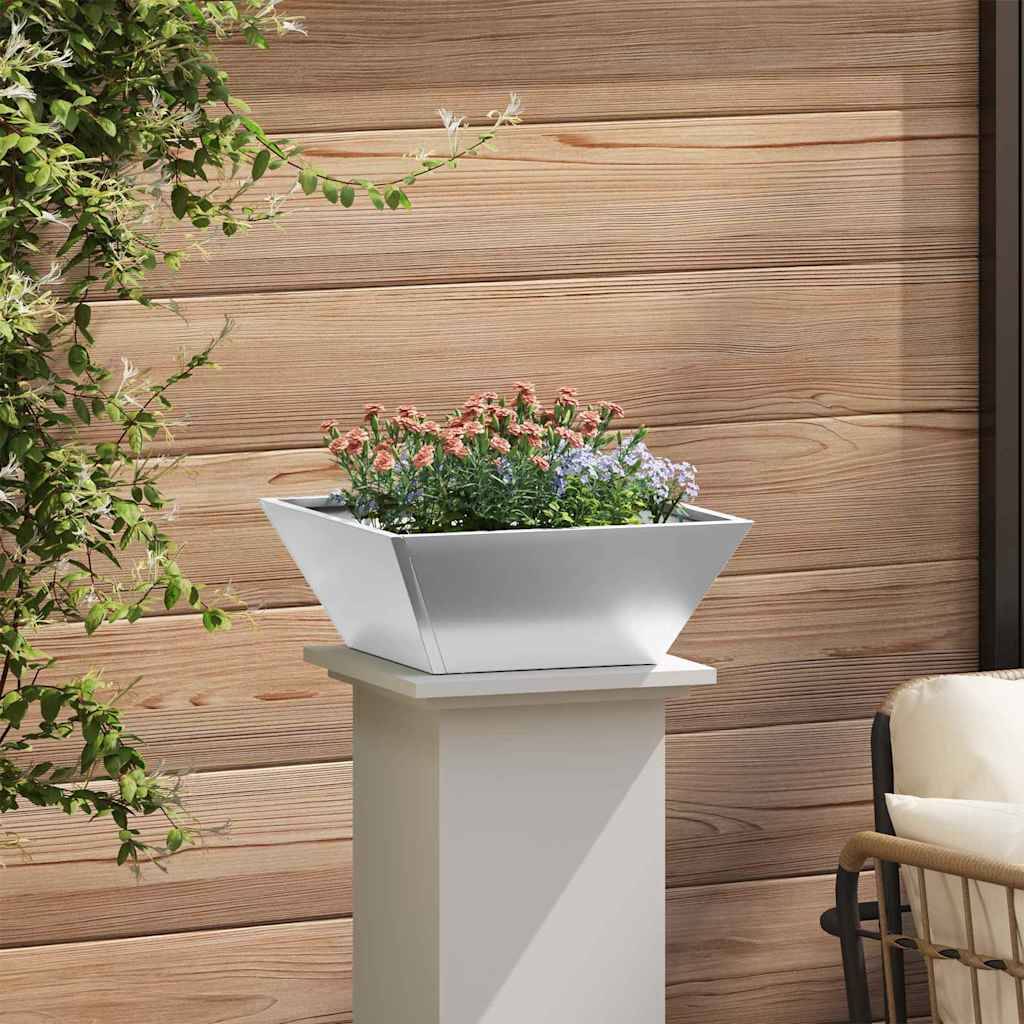 Eine moderne, weiße Pflanzbox, gefüllt mit lebhaften Blumen, steht auf einem weißen Ständer neben einer Holzwand. Eine grüne Ranke fällt von links herab.