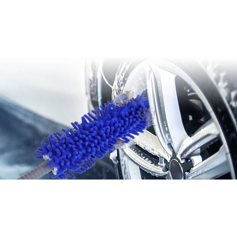 Ein blauer Autoradfelgenbürste reinigt eine silberne Alufelge und entfernt Schmutz und Ablagerungen, während Schnee im Hintergrund sichtbar ist.