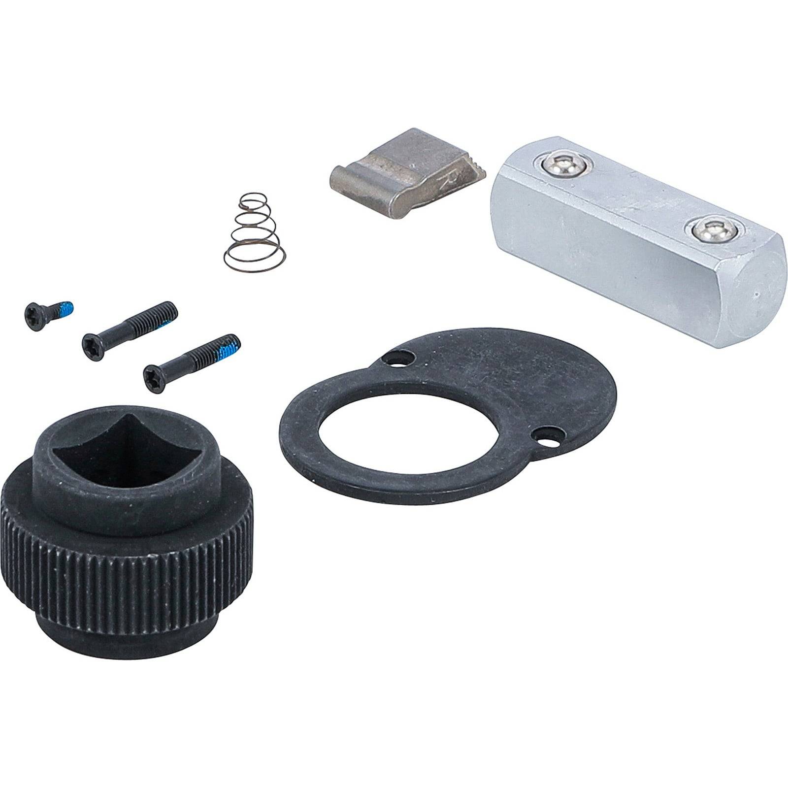 Ein demontierter Ratschenkopf, der ein Zahnrad, zwei Schrauben, eine Feder, einen Metallblock und eine schwarze Scheibe zeigt.