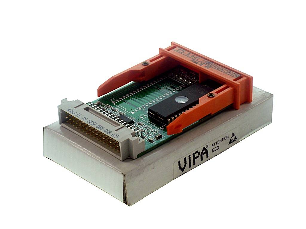 Elektronische Platine in einer orangefarbenen Sockelklemme auf einem weißen Sockel, vermutlich ein Chip-Programmierer oder Testadapter.