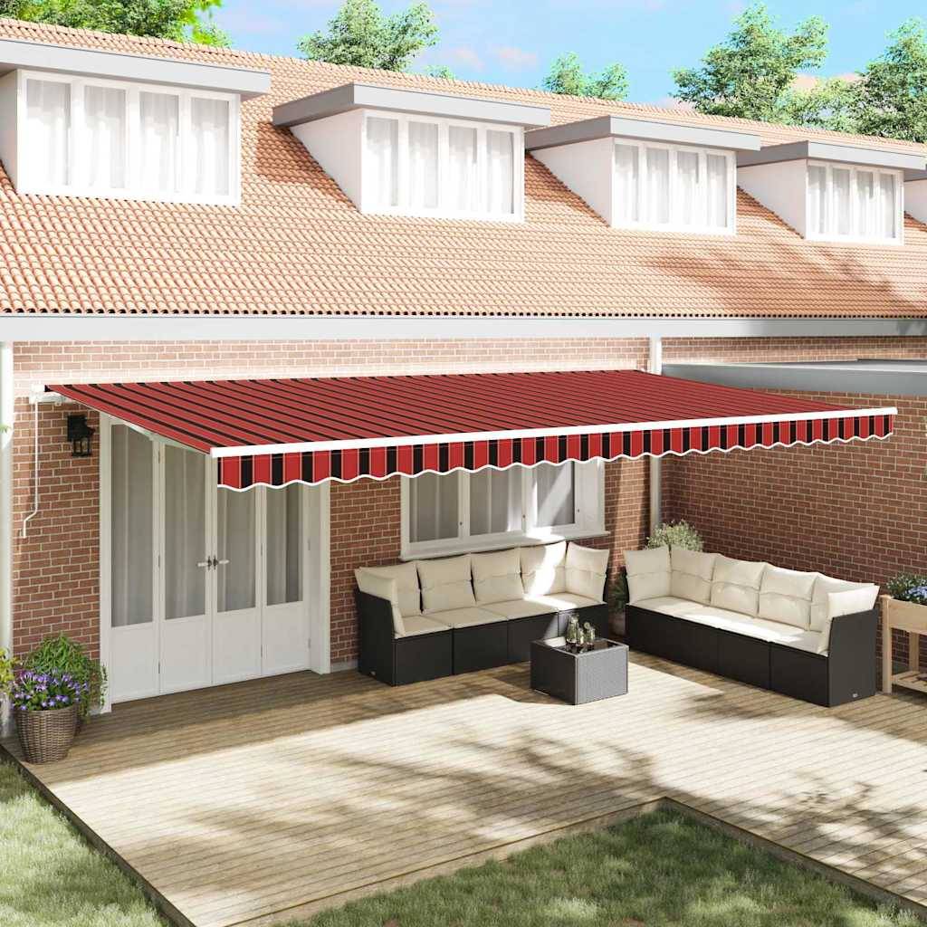 Eine Terrasse mit Ziegelmauern verfügt über eine rot-weiß gestreifte einziehbare Markise. Darunter schaffen weiße Sofas und ein kleiner Tisch eine Sitzgelegenheit.