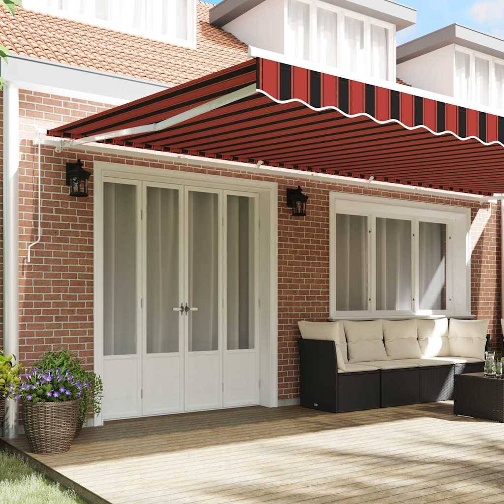 Eine Terrasse mit Holzdielen wird von einem rot-weiß gestreiften Sonnensegel beschattet, das an einem Backsteinhaus befestigt ist. Eine weiße Tür und Fenster sind zu sehen.