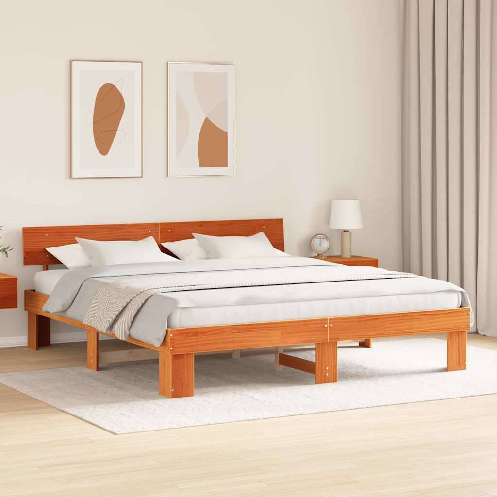 Ein modernes Schlafzimmer mit einem Holzbett mit grauer Bettwäsche, zwei abstrakten gerahmten Kunstwerken darüber und einem kleinen Nachttisch mit einer Lampe.