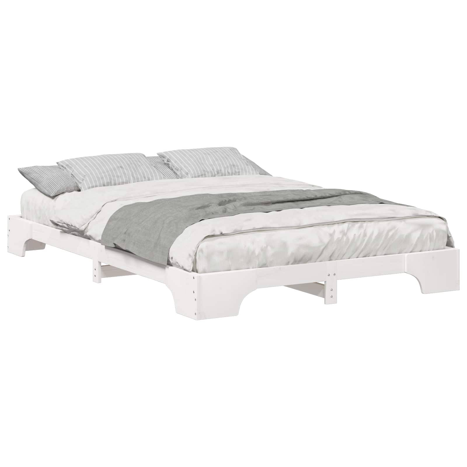 Ein weißes Holzplattformbett mit schlichtem Design, ausgestattet mit grau-weißer Bettwäsche und zwei gestreiften Kissen.